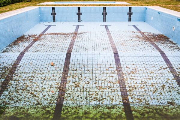 A sparkling clean swimming pool with clear blue water and a pool skimmer.